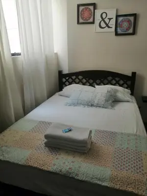 a bed with a quilt and two towels on it at Lopez House Family Aparment in Lima