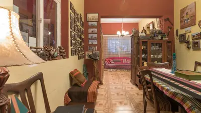 a living room with a table and a chair in a room at Beraja Family Hostel in Lima