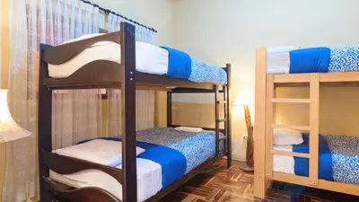 a room with two bunk beds and a lamp at Beraja Family Hostel in Lima