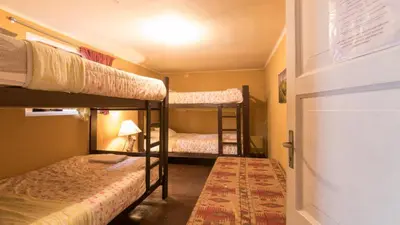 a small room with two bunk beds and a door at Beraja Family Hostel in Lima