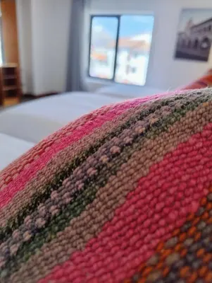 a close up of a colorful blanket on a bed at Central Market Hotel San pedro in Cusco
