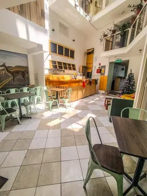a cafeteria with tables and chairs and a christmas tree at Central Market Hotel San pedro in Cusco
