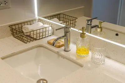 a bathroom sink with a faucet and a mirror at Apartamento acogedor con vista a la calle in Lima