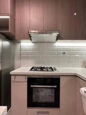 a stove top oven in a kitchen with wooden cabinets at Apartamento acogedor con vista a la calle in Lima