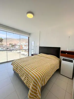 a bedroom with a bed and a window with a view at e-t*| Apartamento frente al mar in Cerro Azul