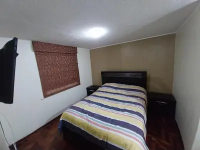 a small bedroom with a bed and a window at Amplio Departamento amoblado, Condominio Parques de la Huaca - San Miguel in Lima