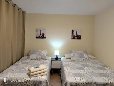 a bedroom with two beds and a table with a lamp at Warmisitay Mini departamento in Lima