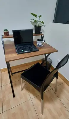 a laptop computer sitting on a wooden table with a chair at Warmisitay Mini departamento in Lima