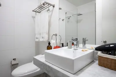a white bathroom with a sink and a toilet at Connect Studios by Vibrant in Lima