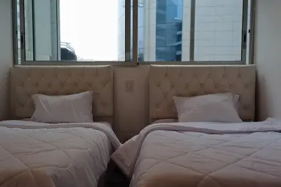two beds in a room with two windows at Luxury Apartments Moon Suites Top in Lima