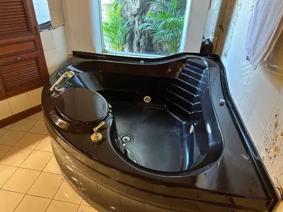 a black bathtub in a bathroom with a window at Casa de Campo Condominio El Pueblo-Santa Clara,Ate in Lima