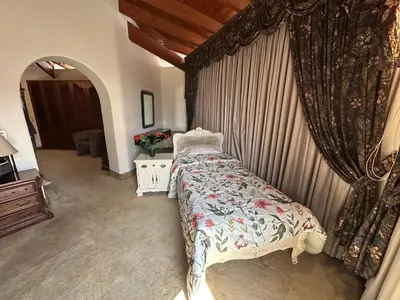 a bedroom with a bed in a room with curtains at Casa de Campo Condominio El Pueblo-Santa Clara,Ate in Lima
