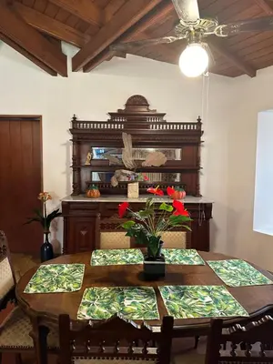 a dining room with a table with flowers on it at Casa de Campo Condominio El Pueblo-Santa Clara,Ate in Lima