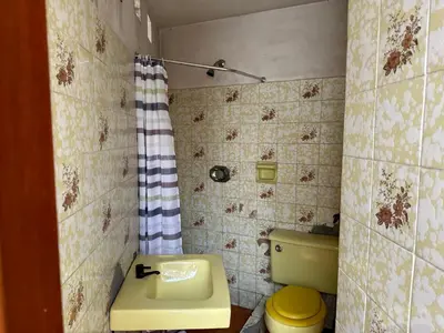 a bathroom with a yellow toilet and a sink at Casa de Campo Condominio El Pueblo-Santa Clara,Ate in Lima
