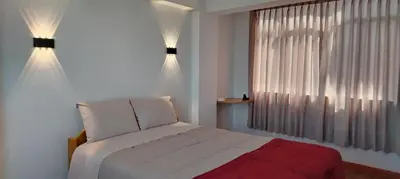 a bedroom with a white bed and a window at Panoramic Cusco in Cusco