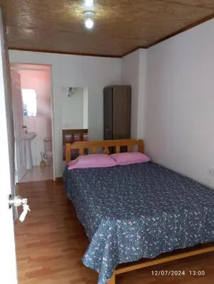 a bedroom with a bed and a bathroom at Hospedaje Casablanca in Pozuzo