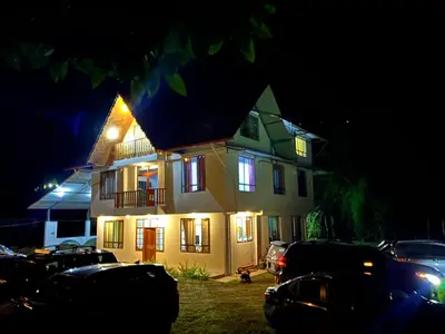 a house with cars parked in front of it at night at Hospedaje Casablanca in Pozuzo