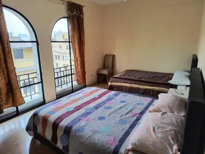 a bedroom with two beds and a large window at Departamento frente a palacio gobierno in Lima