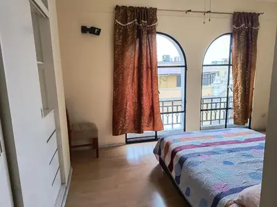 a bedroom with a bed and two large windows at Departamento frente a palacio gobierno in Lima