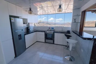 a kitchen with white appliances and a large window at Panoramic Cusco in Cusco