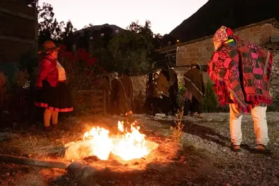 a group of people standing around a fire at La Rosa Wellness Lodge in Urubamba