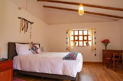 a bedroom with a bed and a window at La Rosa Wellness Lodge in Urubamba