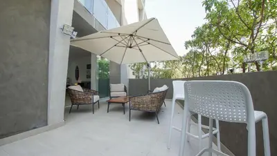 a patio with a table and chairs and an umbrella at Condominio Ocean reef in San Bartolo