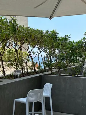 two white chairs sitting on a ledge with trees at Condominio Ocean reef in San Bartolo