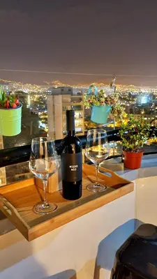 a bottle of wine and two glasses on a table at Habitación con Baño privado en Departamento Compartido in Lima