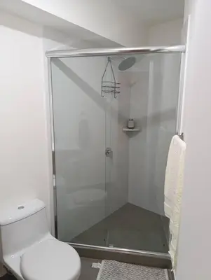a bathroom with a glass shower with a toilet at Piso 31, Último piso, con vista Panorámica in Lima