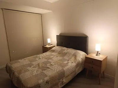 a bedroom with a bed and two night stands with lamps at Piso 31, Último piso, con vista Panorámica in Lima