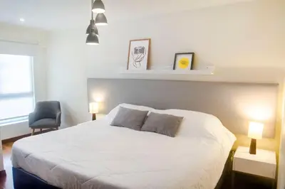 a bedroom with a white bed and a chair at Comfort and Space 3bed and 2 and haf bath centric location in Lima