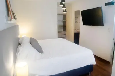 a bedroom with a white bed and a television at Comfort and Space 3bed and 2 and haf bath centric location in Lima