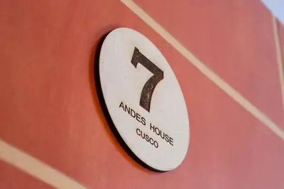 a sign that reads excuses houseclosed on a red wall at Andes House Cusco in Cusco