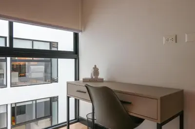 a desk and a chair in a room with a window at Living 110 Suites by Wynwood House in Lima