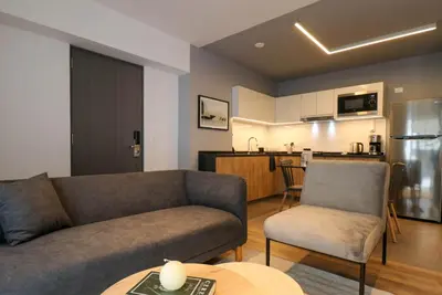 a living room with a couch and a kitchen at Living 110 Suites by Wynwood House in Lima