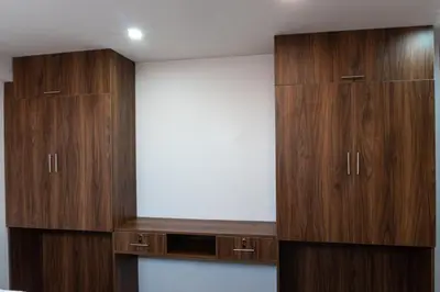 a bedroom with wooden cabinets and a white wall at Lama Vista Living 201 in Cusco