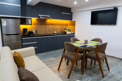 a kitchen and living room with a table and chairs at Lama Vista Living 201 in Cusco