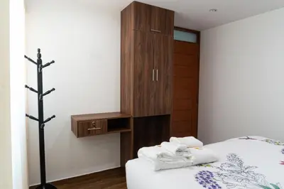a bedroom with a bed and a wooden cabinet at Lama Vista Living 201 in Cusco