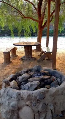 a picnic table and benches next to a fire pit at Soy y Luna- ECOALBERGUE RETABLOS PERU in Lunahuaná