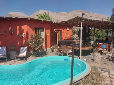 a house with a swimming pool in front of a house at Soy y Luna- ECOALBERGUE RETABLOS PERU in Lunahuaná