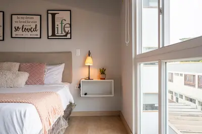a bedroom with a bed with a lamp and a window at Private Residences by Vibrant in Lima