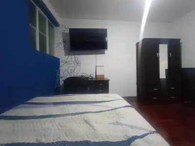 a bedroom with a bed and a flat screen tv at Eli Travelers House in Lima