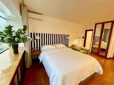 a bedroom with a large white bed and a chair at Loft en el centro de San Isidro Pet Friendly in Lima