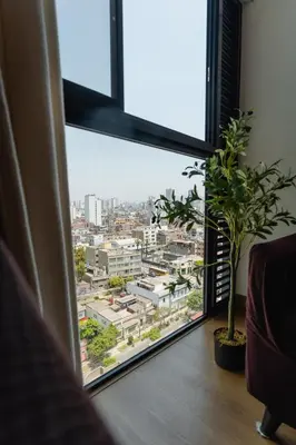 a room with a large window with a view of a city at Family-Friendly 2BR in Prime Location in Lima