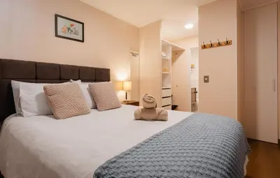 a teddy bear sitting on top of a bed at Family-Friendly 2BR in Prime Location in Lima