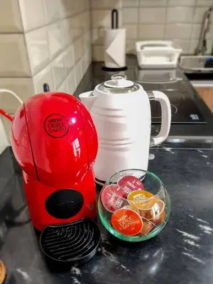 a red blender on a counter next to a bowl of fruit at Apartamento completo en Barranco in Lima