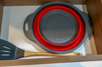 a red and black dish on a shelf with a spatula at Apartamento completo en Barranco in Lima