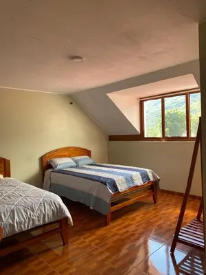 a bedroom with two beds and a window at LagunaNegra Oxapampa in Palmira