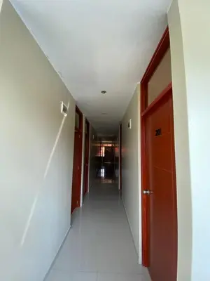 an empty hallway in a building with a red door at LagunaNegra Oxapampa in Palmira
